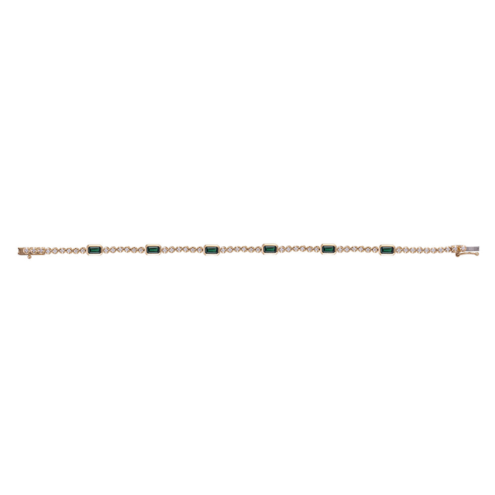 A delicate gold chain bracelet featuring five rectangular emerald-cut green gemstones spaced evenly along the front, displayed horizontally against a solid white background.