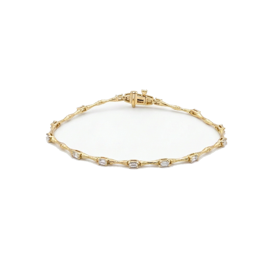 A delicate yellow gold tennis bracelet with small clear gemstones set along the chain, displayed on a clean white background.