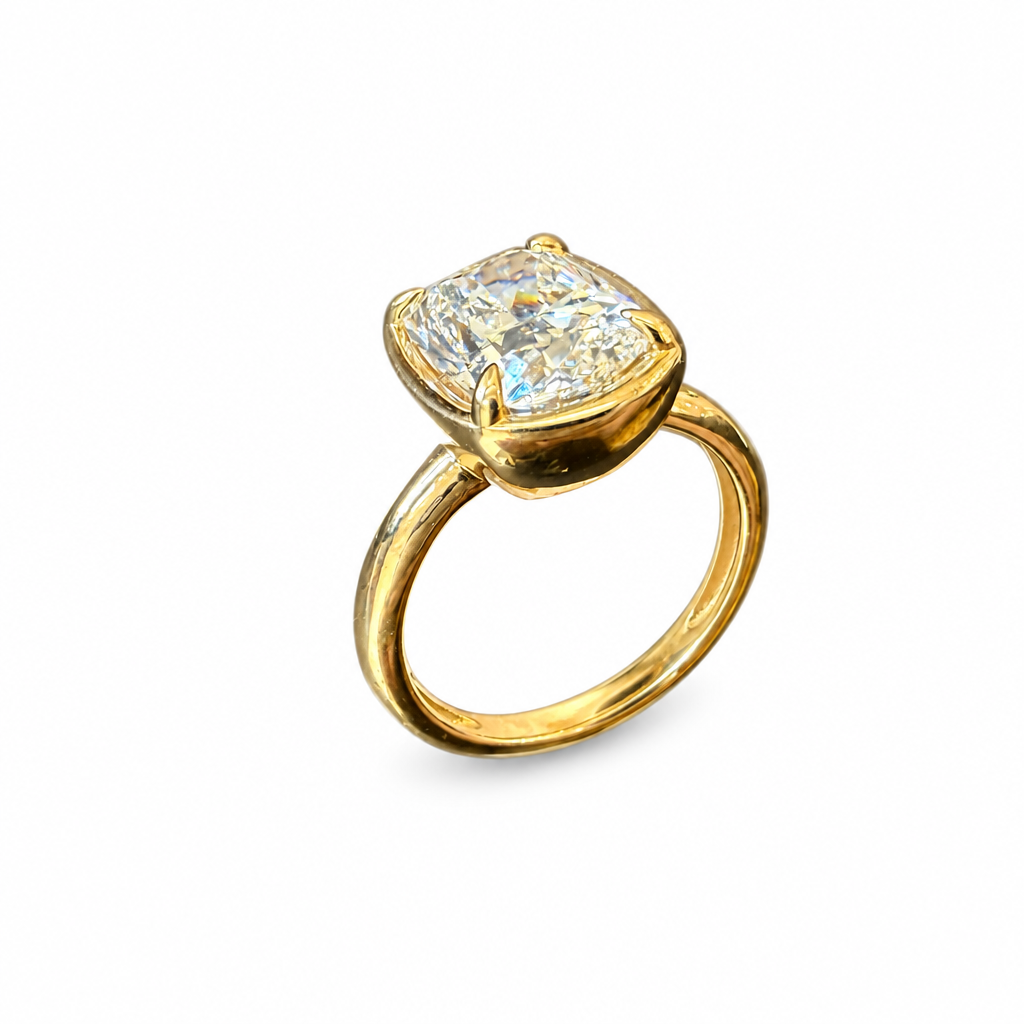 Gold cushion oval diamond ring angled view on white background