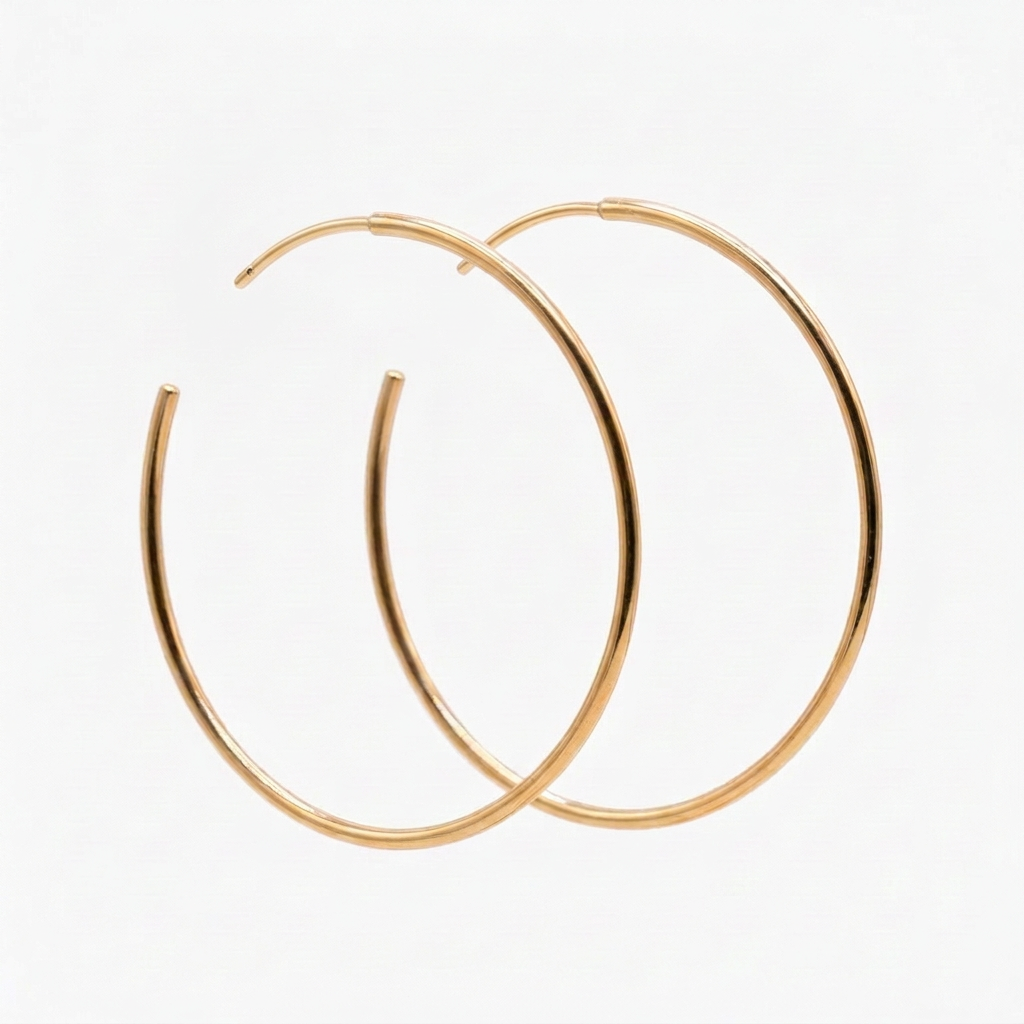 Pair of thin gold Everyday Hoops with curved posts, overlapping on a white background.