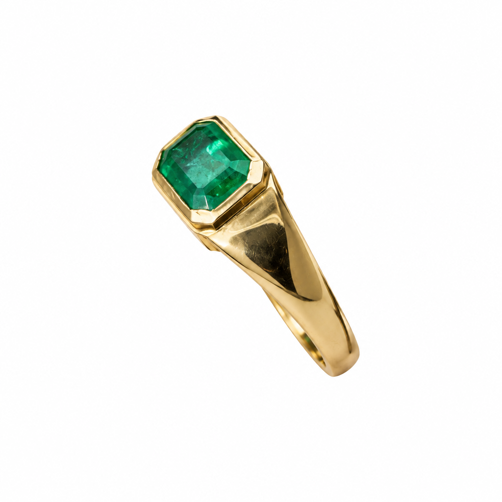 Side view of emerald bezel ring on white background