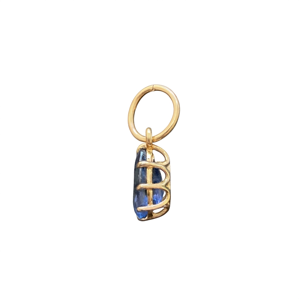 Side view of a teardrop blue sapphire pendant showing the open gold basket setting and oval bail on a white background.