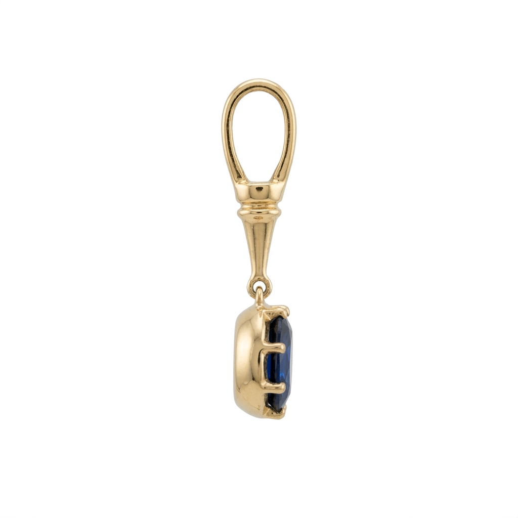 Side view of the Georgian Sapphire Pendant showing the blue sapphire, yellow gold prong setting and elongated oval bail on a white background.