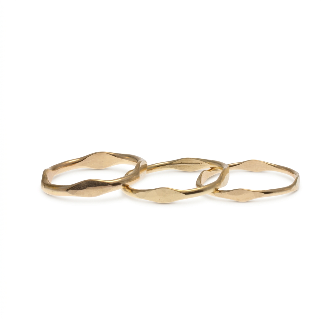 Three gold Lume stacking rings on a white background