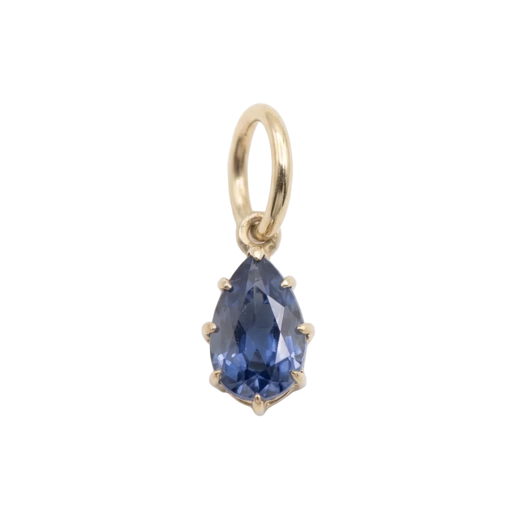 A gold teardrop pendant charm featuring a faceted blue gemstone, set in a six-prong gold bezel and suspended from a gold bail, shown on a white background with a soft shadow.